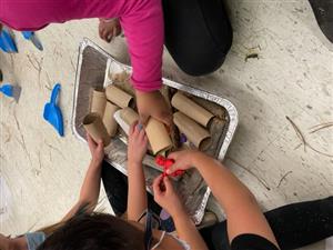 students use earth materials and toilet paper tubes to create a shelter